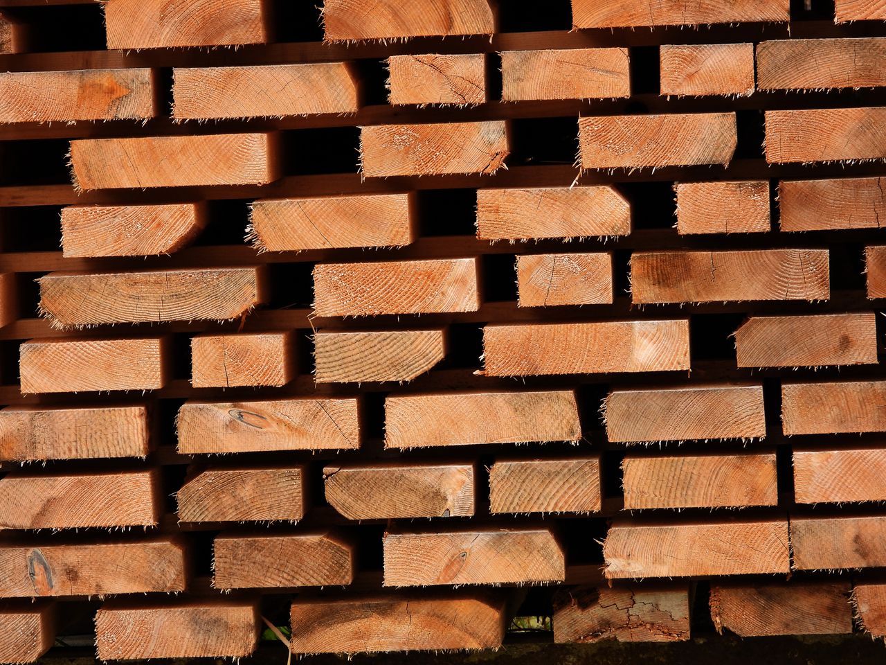 Services Close-up of stacked wooden planks showing texture and grain patterns.