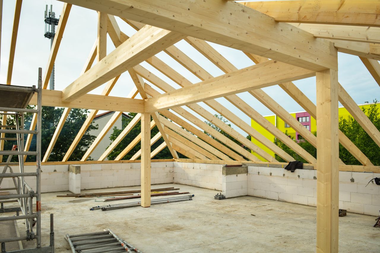 Services Wooden roof structure in progress with open sky view, ideal for construction themes.